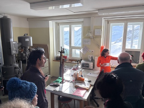 Custodian Sonya Stöckli explains a decades long experiment, constantly collecting CO2 from the atmosphere to be sent off for radiocarbon dating; CO2 produced by burning fossil fuels can be clearly differentiated from non-fossil fuel sources by measuring carbon-14.